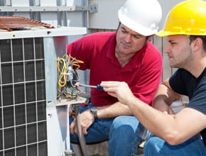 Electricians checking wires on an AC